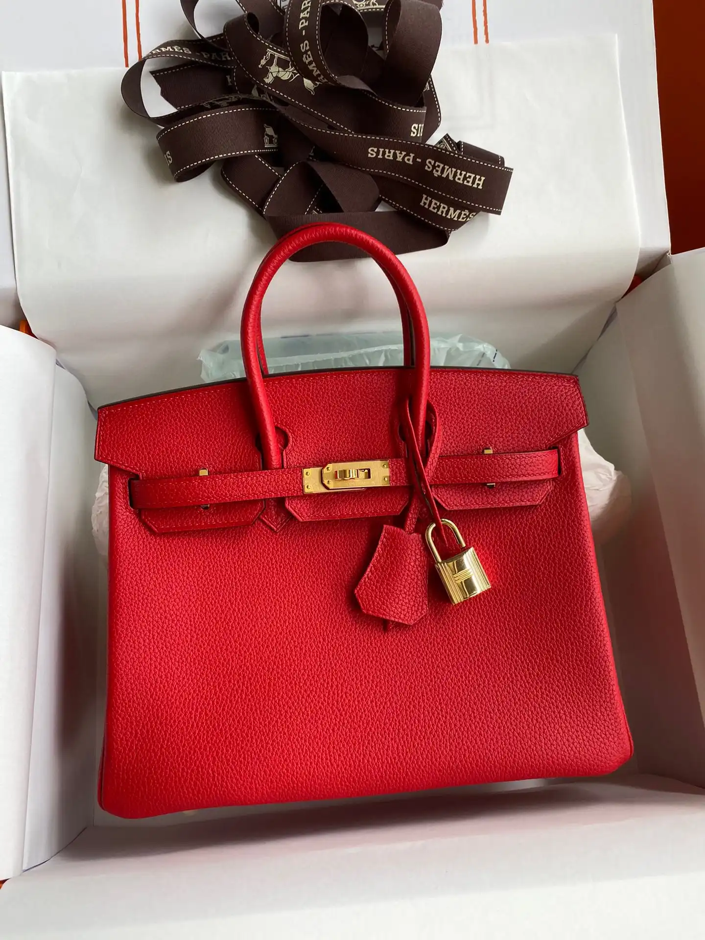 Discover the elegance of the Hermes Birkin in vibrant red Togo leather, adorned with luxurious gold accents. A timeless treasure! ❤️✨ https://tinyurl.com/2agbhnpy