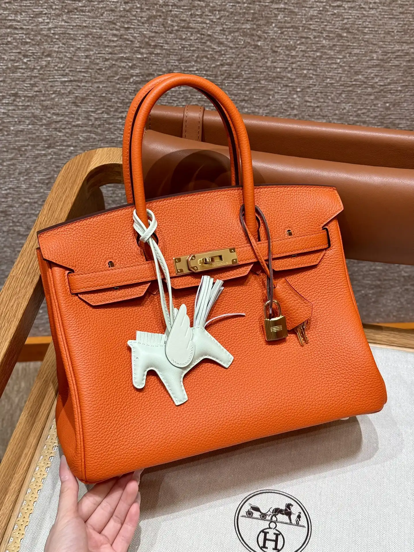 Discover the timeless elegance of the Hermes Birkin in vibrant orange Togo leather, beautifully accented with gold. 🌟👜✨ A treasure to cherish! https://tinyurl.com/268fonk7